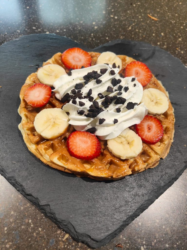 Loaded waffle with banana, strawberries and cream
