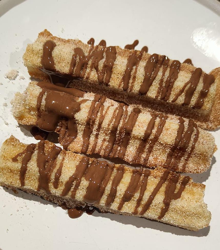 Freshly made churros with chocolate drizzle