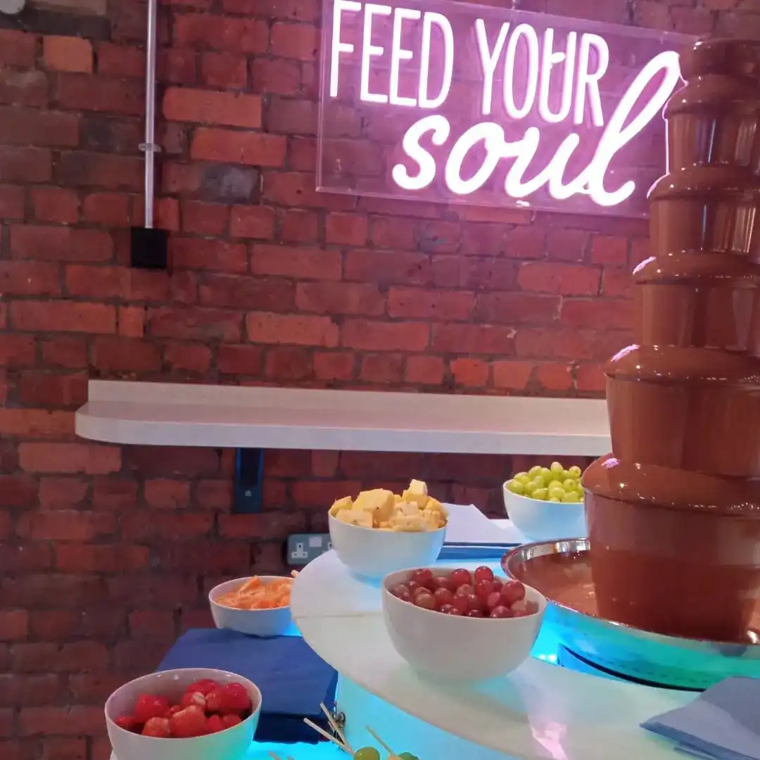 Chocolate fountain with a pink neon sign