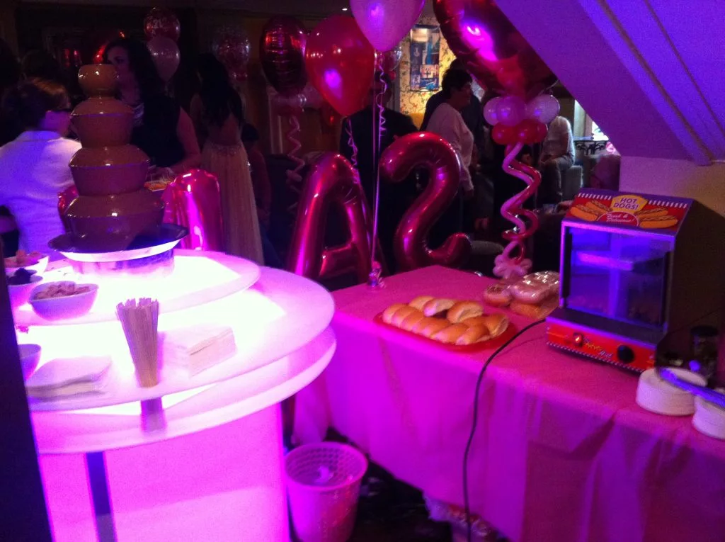 Chocolate fountain lit up on an LED base at an evening party
