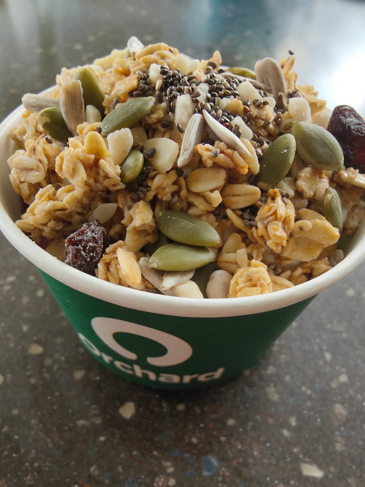 Breakfast bowl topped with granola, pumpkin seeds, sunflower seeds and chia seeds