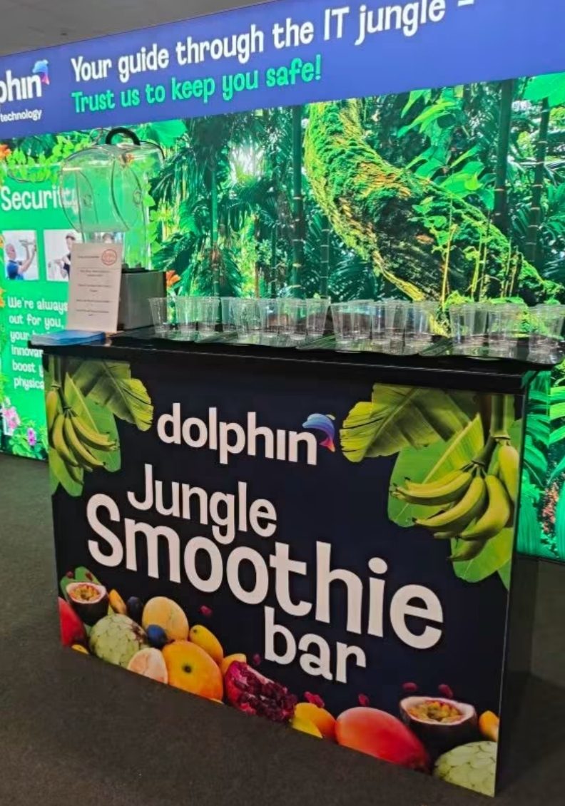 Branded smoothie bar on an exhibition stand with rows of cups ready to serve