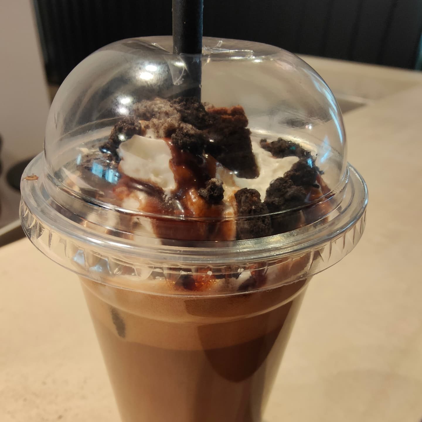 Chocolate milkshake topped with whipped cream, chocolate sauce and Oreo crumb