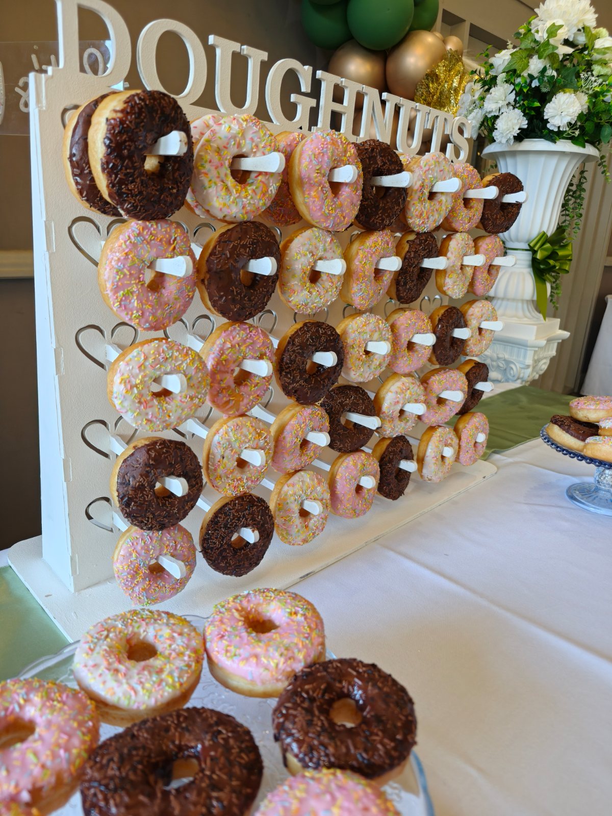 Close-up of a doughnut wall with pink, white and chocolate iced ring doughnuts