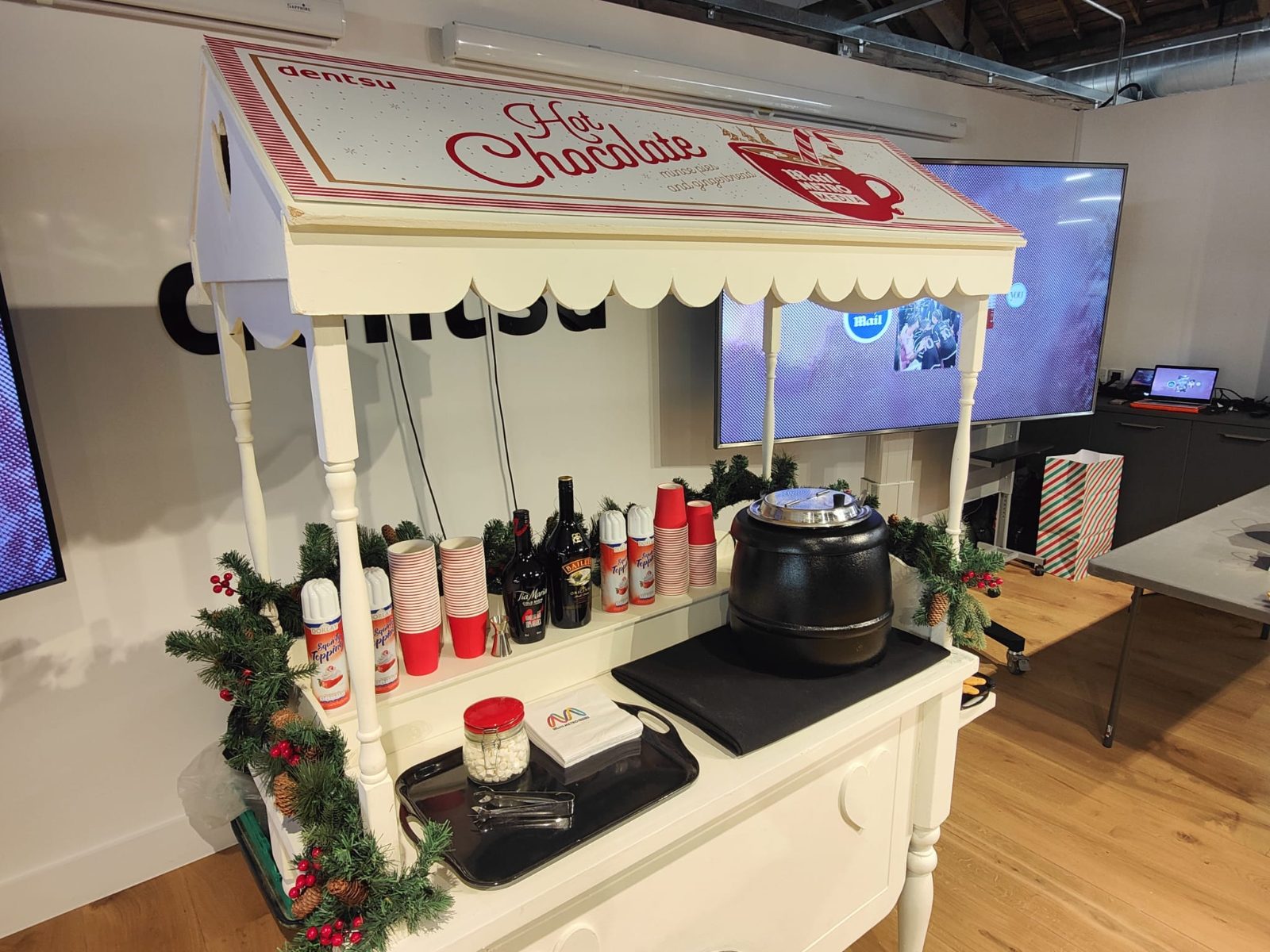 Branded hot chocolate cart with cups, squirty cream and marshmallows at a corporate Christmas event